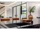 Stylish kitchen island with a sink, seating, and views of the living area and outdoor space at 8038 E Clarendon Ave, Scottsdale, AZ 85251