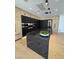 Modern kitchen with stainless steel appliances, black countertops and an island with a built in sink at 8038 E Clarendon Ave, Scottsdale, AZ 85251