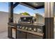Outdoor kitchen with built-in grill and bar area at 8038 E Clarendon Ave, Scottsdale, AZ 85251