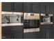 Gourmet kitchen featuring stainless steel Wolf ovens and a coffee maker set in dark wood cabinetry at 8038 E Clarendon Ave, Scottsdale, AZ 85251