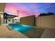 Backyard pool with travertine tile, a waterfall feature wall, and a covered outdoor kitchen area at 8038 E Clarendon Ave, Scottsdale, AZ 85251