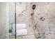 Elegant shower with marble tile, gold trim, and a handheld shower head for a luxurious experience at 8038 E Clarendon Ave, Scottsdale, AZ 85251