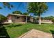 Spacious backyard with lush green grass, mature trees, and a covered patio at 8315 E Vernon Ave, Scottsdale, AZ 85257