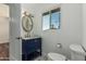 Well-lit bathroom featuring a navy vanity, decorative mirror, and charming hexagonal tile flooring at 8315 E Vernon Ave, Scottsdale, AZ 85257