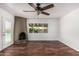 Cozy room showcasing a rustic fireplace, wood floors, large window, and a ceiling fan at 8315 E Vernon Ave, Scottsdale, AZ 85257