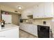 Kitchen featuring white cabinetry, tile flooring, and black appliances at 8532 E Sheridan St, Scottsdale, AZ 85257
