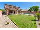 Spacious backyard featuring a well-maintained lawn, pool with mature palms, and a covered patio area for outdoor entertaining at 9051 W Iona Way, Peoria, AZ 85383