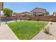 Beautiful backyard with well-maintained lawn, lush plants, and a sparkling pool at 9051 W Iona Way, Peoria, AZ 85383