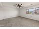 Spacious bedroom features a ceiling fan, window with blinds, and neutral carpet at 9051 W Iona Way, Peoria, AZ 85383
