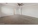 Spacious bedroom featuring neutral carpet, ceiling fan, and multiple doors to bathroom at 9051 W Iona Way, Peoria, AZ 85383