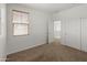 Empty bedroom featuring neutral carpet, blinds, and adjacent closet at 9051 W Iona Way, Peoria, AZ 85383