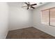 Cozy bedroom showcasing plush carpet, a ceiling fan, and window with wood blinds for natural light at 9051 W Iona Way, Peoria, AZ 85383