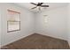 Well-lit bedroom showing plush carpeting, a ceiling fan, and windows dressed with wood blinds at 9051 W Iona Way, Peoria, AZ 85383