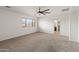 Large bedroom featuring a ceiling fan, neutral carpet, and window with blinds at 9051 W Iona Way, Peoria, AZ 85383