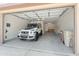 View of a large two car garage with a white SUV, with overhead lighting, and storage space at 9051 W Iona Way, Peoria, AZ 85383