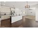 Open kitchen showcases granite counters, island, stainless appliances, and dark wood floors at 9051 W Iona Way, Peoria, AZ 85383