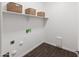 Well-lit laundry room with wood look flooring, overhead shelving, and utility connections at 9051 W Iona Way, Peoria, AZ 85383