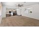 Spacious living room featuring an opening view to a well-appointed kitchen and a modern ceiling fan at 9051 W Iona Way, Peoria, AZ 85383