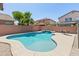 Private backyard pool surrounded by lush landscaping, patio, and brick wall at 9051 W Iona Way, Peoria, AZ 85383
