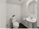 Cozy powder room with pedestal sink, decorative mirror, and modern toilet at 9051 W Iona Way, Peoria, AZ 85383