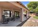 Covered patio with rocking chairs and a view of the spacious backyard and mature landscaping at 941 E Stirrup Ln, San Tan Valley, AZ 85143