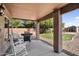 Covered patio with rocking chairs, a grill, and a view of the backyard and storage shed at 941 E Stirrup Ln, San Tan Valley, AZ 85143