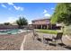 Expansive backyard with a pool, artificial grass, and a seating area, perfect for relaxation at 941 E Stirrup Ln, San Tan Valley, AZ 85143