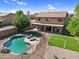Relaxing backyard features a pool, lounge area, covered patio, and a well-kept lawn at 941 E Stirrup Ln, San Tan Valley, AZ 85143