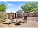 Cozy backyard with a storage shed, gravel, fire pit with chairs, and a fenced yard with mature trees at 941 E Stirrup Ln, San Tan Valley, AZ 85143
