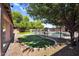 Wide backyard with artificial turf, mature shade trees, a storage shed, and desert landscaping at 941 E Stirrup Ln, San Tan Valley, AZ 85143