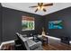Bedroom with dark walls, TV, guitar, hardwood floors, and window views at 941 E Stirrup Ln, San Tan Valley, AZ 85143