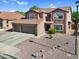 Aerial front view of a two-story home with a three-car garage, desert landscaping, and a neutral color palette at 941 E Stirrup Ln, San Tan Valley, AZ 85143
