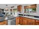 Modern kitchen with cherry cabinets, black countertops, stainless dishwasher, and a view of the backyard pool at 941 E Stirrup Ln, San Tan Valley, AZ 85143