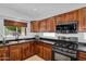 Contemporary kitchen with dark countertops, stainless steel appliances, and stylish wood cabinets at 941 E Stirrup Ln, San Tan Valley, AZ 85143