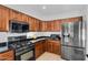 Contemporary kitchen with stainless steel appliances, dark countertops, and rich wood cabinetry at 941 E Stirrup Ln, San Tan Valley, AZ 85143