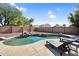 Inviting backyard pool with a waterfall feature and comfortable lounge chairs for relaxation at 941 E Stirrup Ln, San Tan Valley, AZ 85143