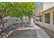 Beautifully landscaped backyard with mature trees, rock features, and a paved walkway, creating a serene outdoor space at 9839 W Utopia Rd, Peoria, AZ 85382