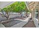 Lush backyard with mature trees and rock features, easily accessible from the covered patio, creating a tranquil retreat at 9839 W Utopia Rd, Peoria, AZ 85382