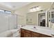 Bathroom with sliding shower door, toilet, and sink with wood cabinet at 9839 W Utopia Rd, Peoria, AZ 85382