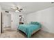 Bright bedroom featuring a ceiling fan, plush carpeting, and a comfortable teal-colored bedspread at 9839 W Utopia Rd, Peoria, AZ 85382