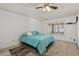 Bright bedroom featuring a ceiling fan, plush carpeting, and a comfortable teal-colored bedspread at 9839 W Utopia Rd, Peoria, AZ 85382