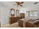 Bedroom features a decorative dresser, mirrors, ceiling fan, and a bed with side tables at 9839 W Utopia Rd, Peoria, AZ 85382