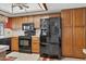 Traditional kitchen with black appliances, tiled backsplash, and wood cabinets provides function and convenience at 9839 W Utopia Rd, Peoria, AZ 85382