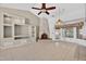 Living room featuring a stone fireplace, vaulted ceilings, built-in shelves, and neutral tile at 9839 W Utopia Rd, Peoria, AZ 85382