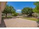 A backyard patio area with interlocking pavers, beautiful landscaping, and a cozy outdoor fire pit at 1063 W Vaughn St, Tempe, AZ 85283