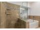 Updated bathroom features a walk-in shower with glass enclosure, soaking tub, and tiled walls with decorative accents at 1063 W Vaughn St, Tempe, AZ 85283