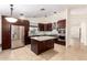 Spacious kitchen with stainless steel appliances, granite counters, large center island, and dark wood cabinetry at 1063 W Vaughn St, Tempe, AZ 85283