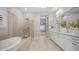 Bright bathroom features a soaking tub, glass-enclosed shower, and dual sink vanity with modern fixtures at 1123 W Thunderhill Dr, Phoenix, AZ 85045