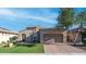 Single-story home with a neutral-colored stucco exterior, tile roof, brick driveway, and arched entry at 1123 W Thunderhill Dr, Phoenix, AZ 85045