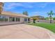 A spacious backyard with a covered patio, artificial grass, and lush landscaping at 11306 E Rembrandt Ave, Mesa, AZ 85212